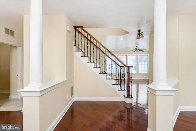 stairway featuring wood-type flooring, decorative columns, and ceiling fan