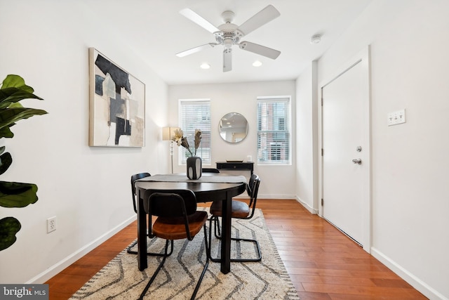 dining space featuring wood-type flooring and ceiling fan