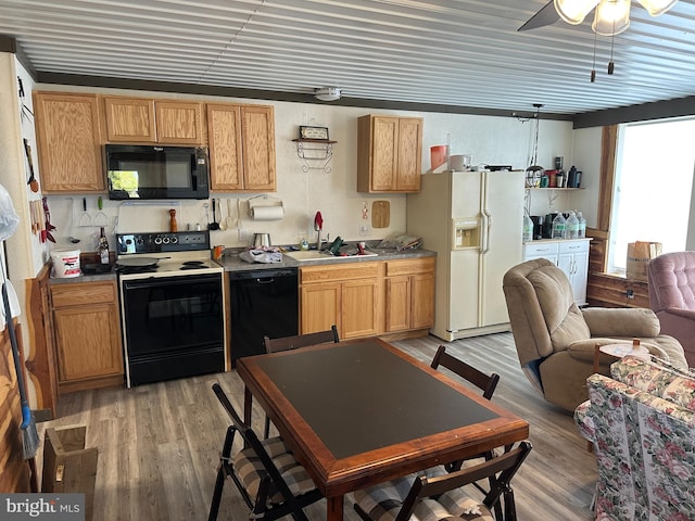 kitchen with black appliances, crown molding, light hardwood / wood-style flooring, ceiling fan, and sink