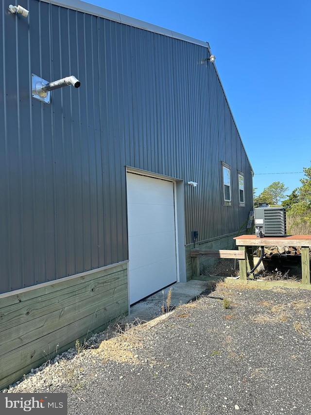 view of side of property with cooling unit and a garage