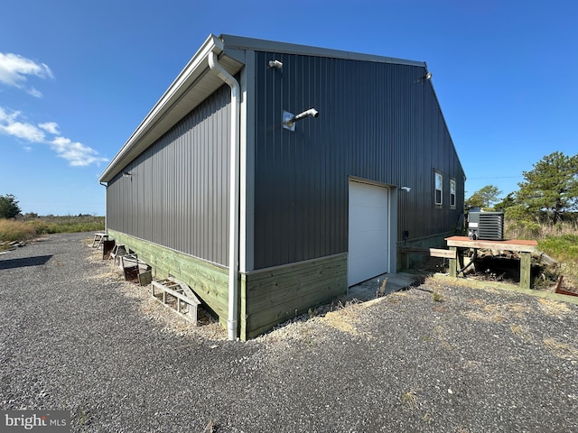 view of side of home featuring an outdoor structure, central air condition unit, and a garage