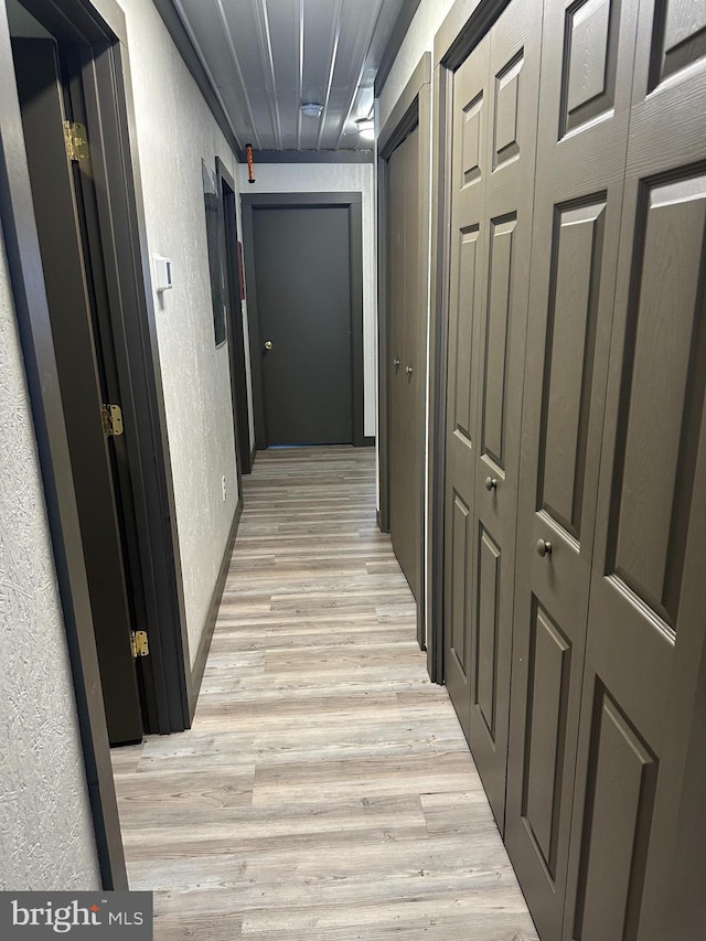 hallway with light hardwood / wood-style floors