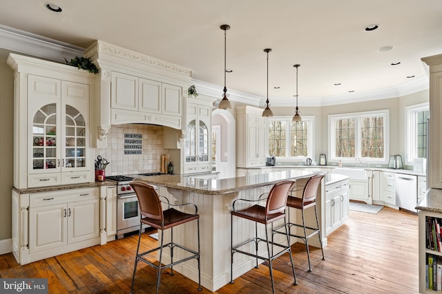 kitchen featuring light hardwood / wood-style flooring, stainless steel appliances, a kitchen breakfast bar, and a center island