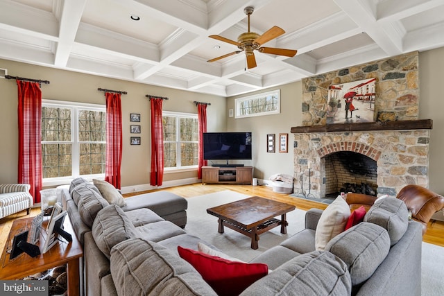 living room with coffered ceiling, a fireplace, light wood-type flooring, beam ceiling, and ceiling fan