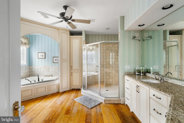 bathroom featuring shower with separate bathtub, wood-type flooring, plenty of natural light, and vanity