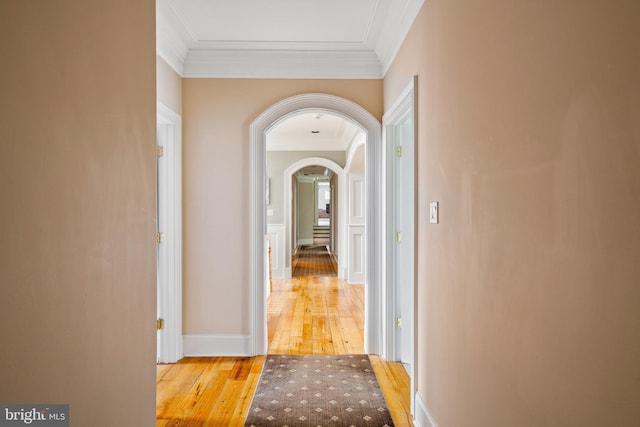 hall with wood-type flooring and ornamental molding