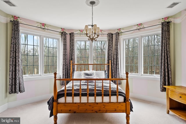 carpeted bedroom featuring an inviting chandelier and multiple windows