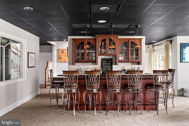 bar featuring a paneled ceiling and light colored carpet