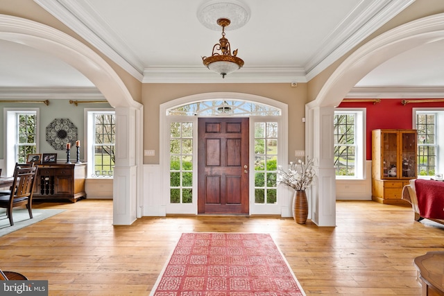 entryway with crown molding and light hardwood / wood-style floors