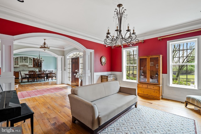 living room featuring ornamental molding, wood-type flooring, and a healthy amount of sunlight