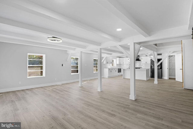 basement with sink and light hardwood / wood-style floors