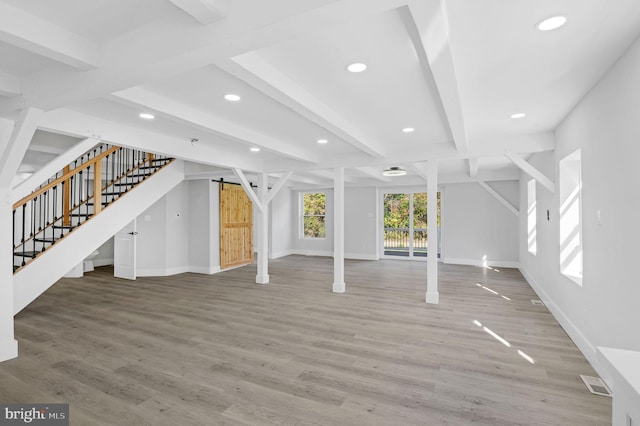 unfurnished living room featuring wood-type flooring and beam ceiling