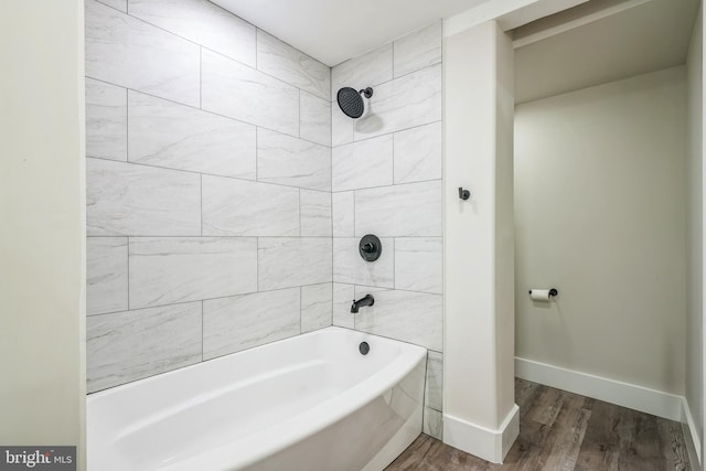 bathroom with tiled shower / bath combo and hardwood / wood-style flooring