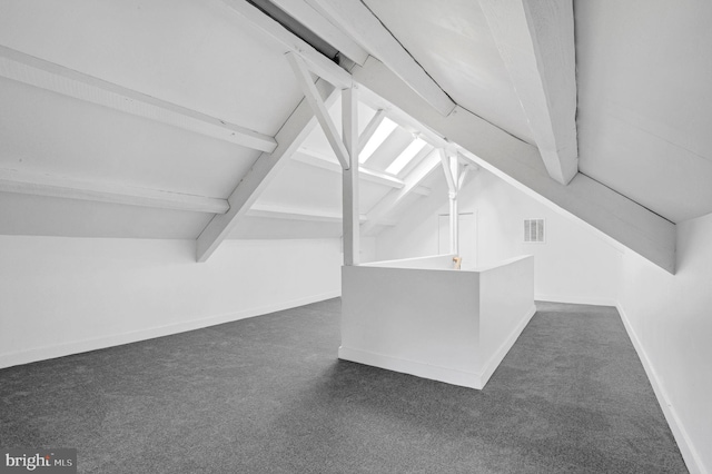 bonus room with lofted ceiling with beams and dark carpet