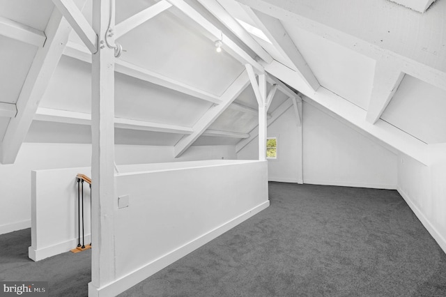 bonus room featuring vaulted ceiling and dark carpet