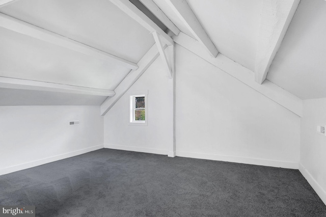 bonus room with lofted ceiling with beams and dark carpet