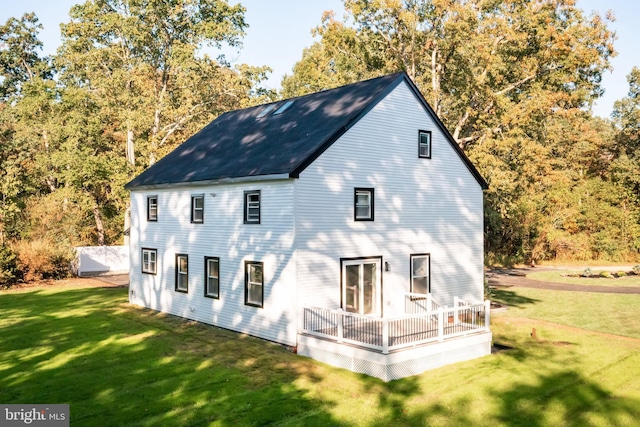 back of house with a deck and a yard