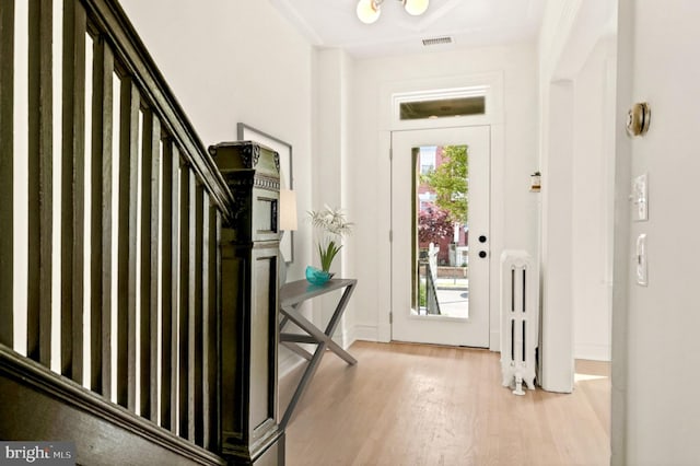 foyer featuring light hardwood / wood-style floors and radiator heating unit