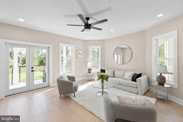 living room with ceiling fan, french doors, light hardwood / wood-style flooring, and a healthy amount of sunlight