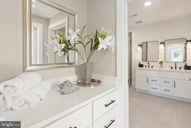 bathroom featuring tile patterned flooring, vanity, and a shower with shower door