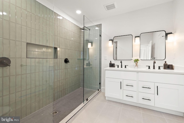 bathroom featuring tile patterned flooring, an enclosed shower, and vanity