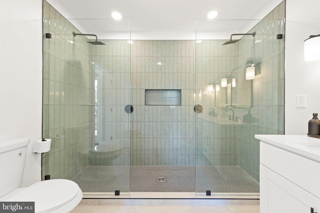 bathroom with tile patterned flooring, vanity, walk in shower, and toilet