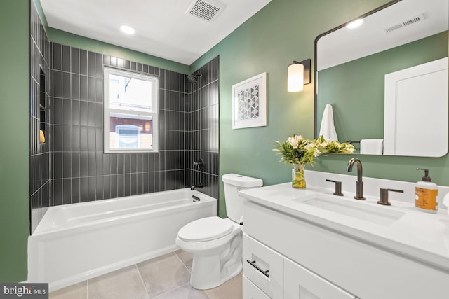 full bathroom with tiled shower / bath, tile patterned floors, vanity, and toilet