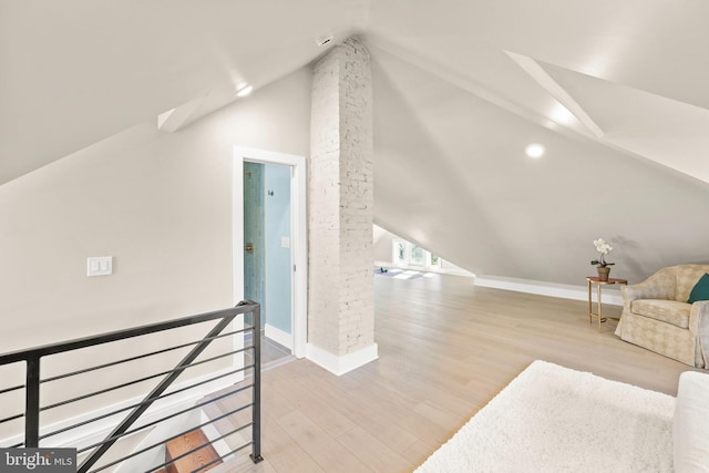 additional living space featuring lofted ceiling and light wood-type flooring