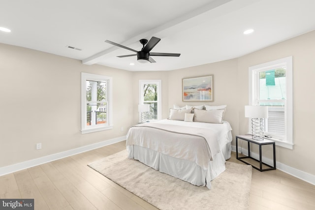 bedroom featuring ceiling fan, beamed ceiling, and light hardwood / wood-style flooring