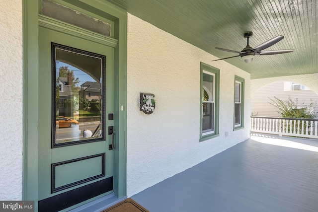 entrance to property featuring an AC wall unit and ceiling fan