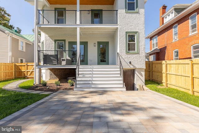 view of front of house with a balcony and a patio area