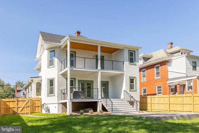 back of property featuring a yard and a balcony