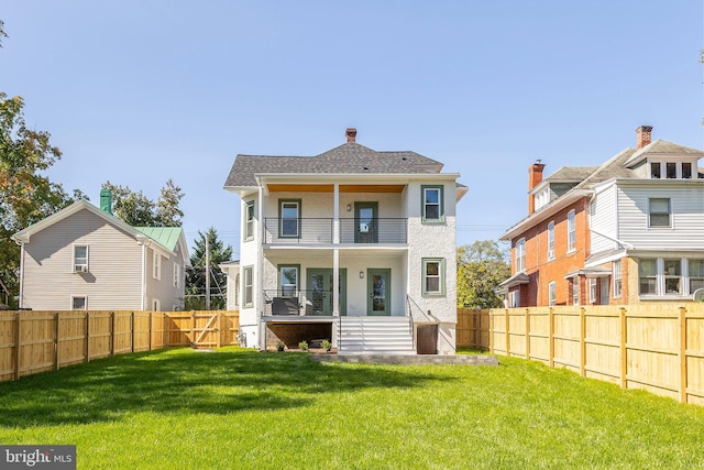 rear view of property featuring a balcony and a lawn