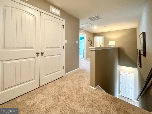 hallway with light colored carpet