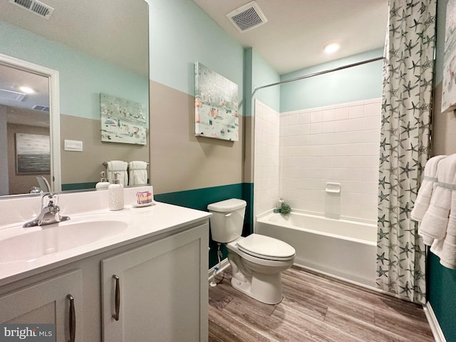 full bathroom featuring hardwood / wood-style floors, vanity, shower / bath combo with shower curtain, and toilet