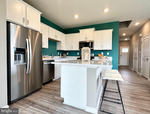 kitchen featuring light hardwood / wood-style flooring, stainless steel appliances, and white cabinets