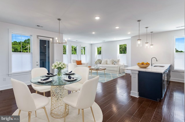 dining area featuring an inviting chandelier, dark hardwood / wood-style floors, and sink