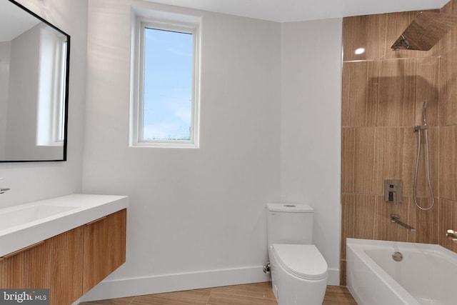 full bathroom with toilet, tiled shower / bath, hardwood / wood-style floors, and vanity