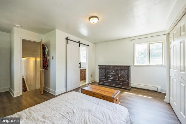 bedroom featuring dark wood-type flooring, a barn door, connected bathroom, a closet, and a baseboard radiator