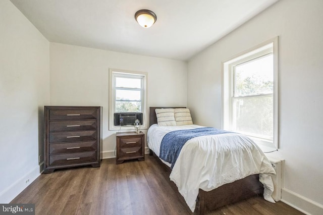 bedroom with multiple windows, cooling unit, and dark hardwood / wood-style floors