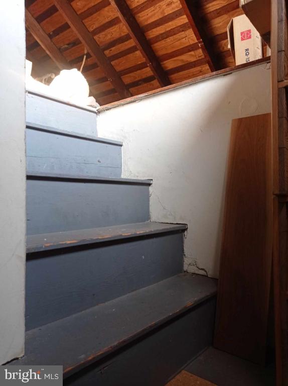 stairs with beam ceiling and wooden ceiling