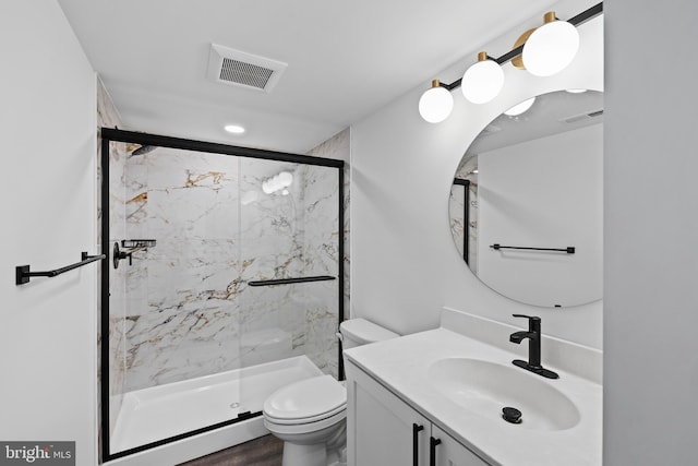 bathroom featuring a shower with door, vanity, hardwood / wood-style floors, and toilet