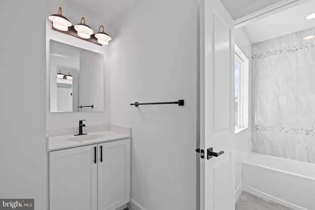 bathroom featuring tiled shower / bath combo, a wealth of natural light, and vanity