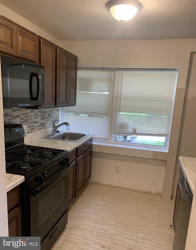 kitchen with black appliances, dark brown cabinets, backsplash, and sink