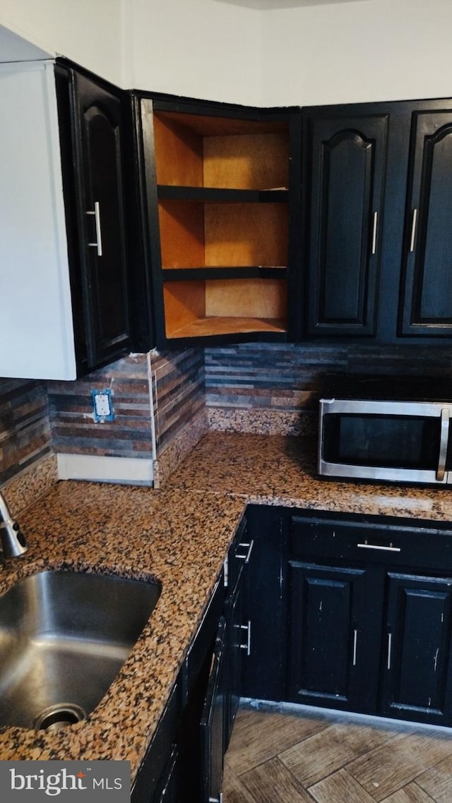 kitchen with stone counters, sink, and decorative backsplash