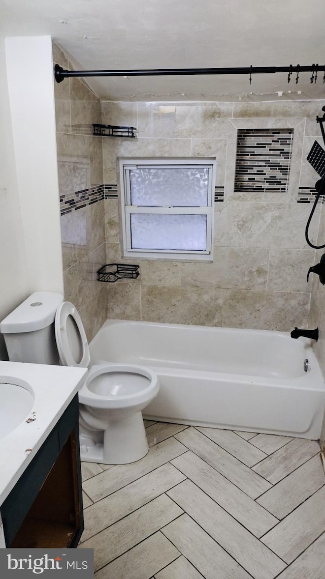 full bathroom with vanity, tiled shower / bath combo, and toilet