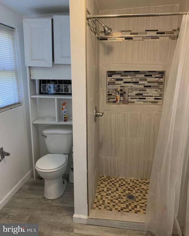 bathroom featuring toilet and a shower with shower curtain