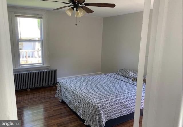 bedroom with ceiling fan, dark hardwood / wood-style flooring, and radiator heating unit