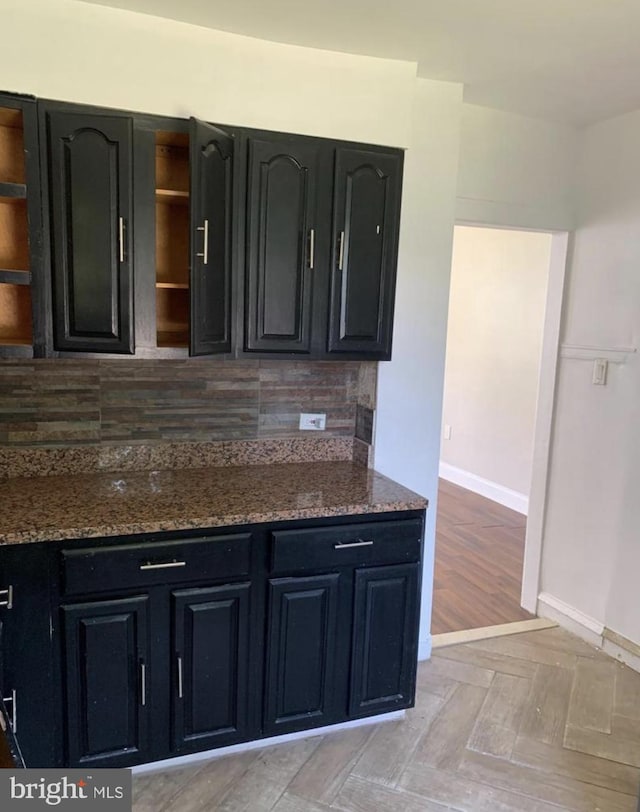 kitchen with decorative backsplash and dark stone counters