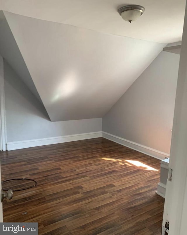 additional living space with lofted ceiling and dark hardwood / wood-style flooring